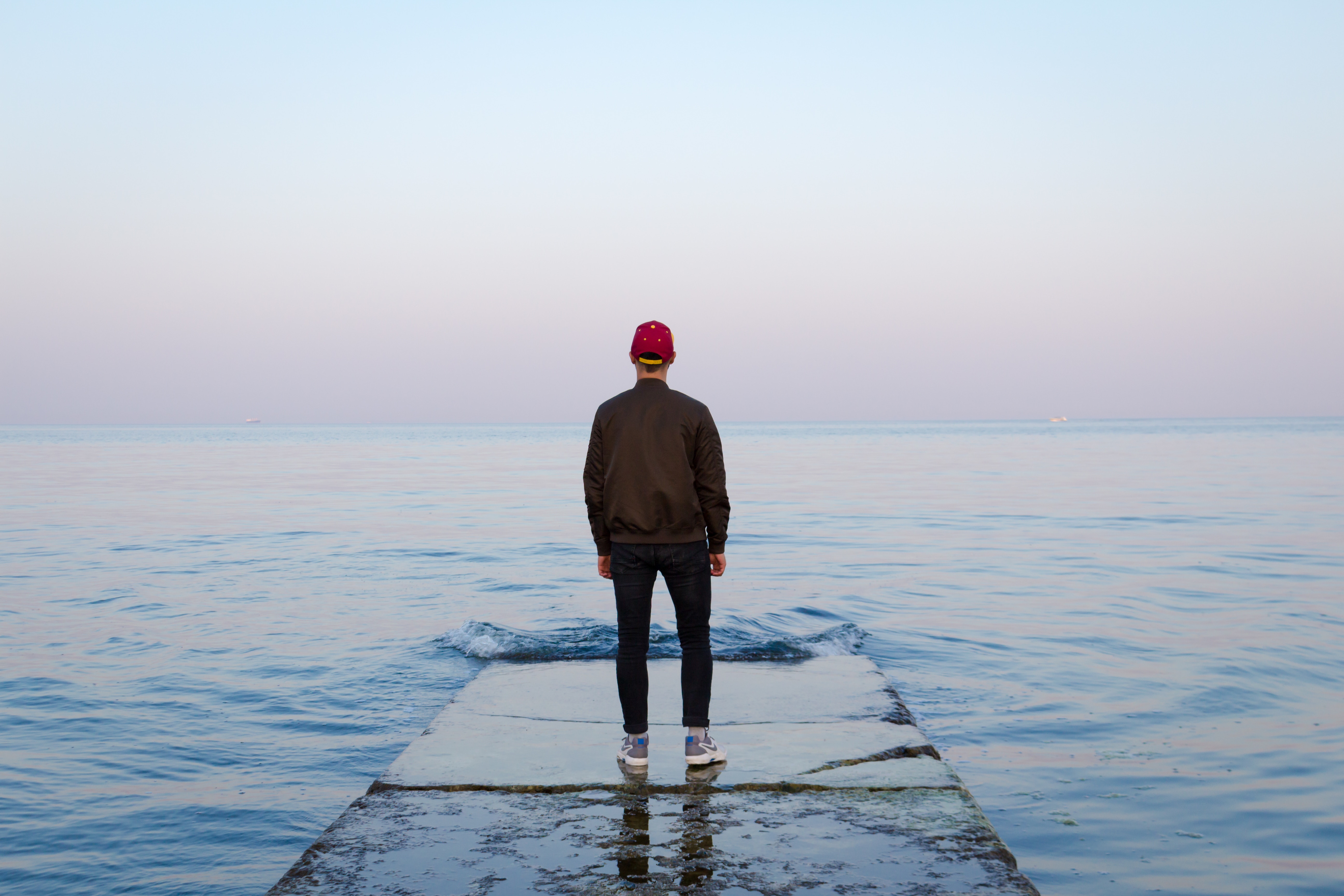 Man standing on edge of pier